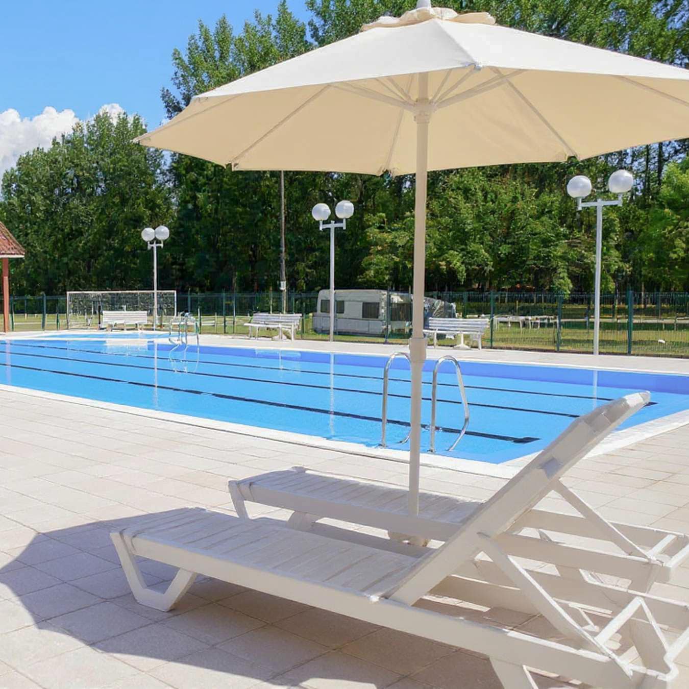 transats et parasol au bord de la piscine 2